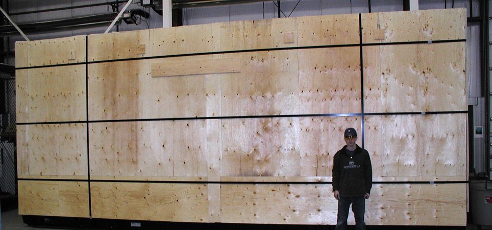 man standing next to large crates